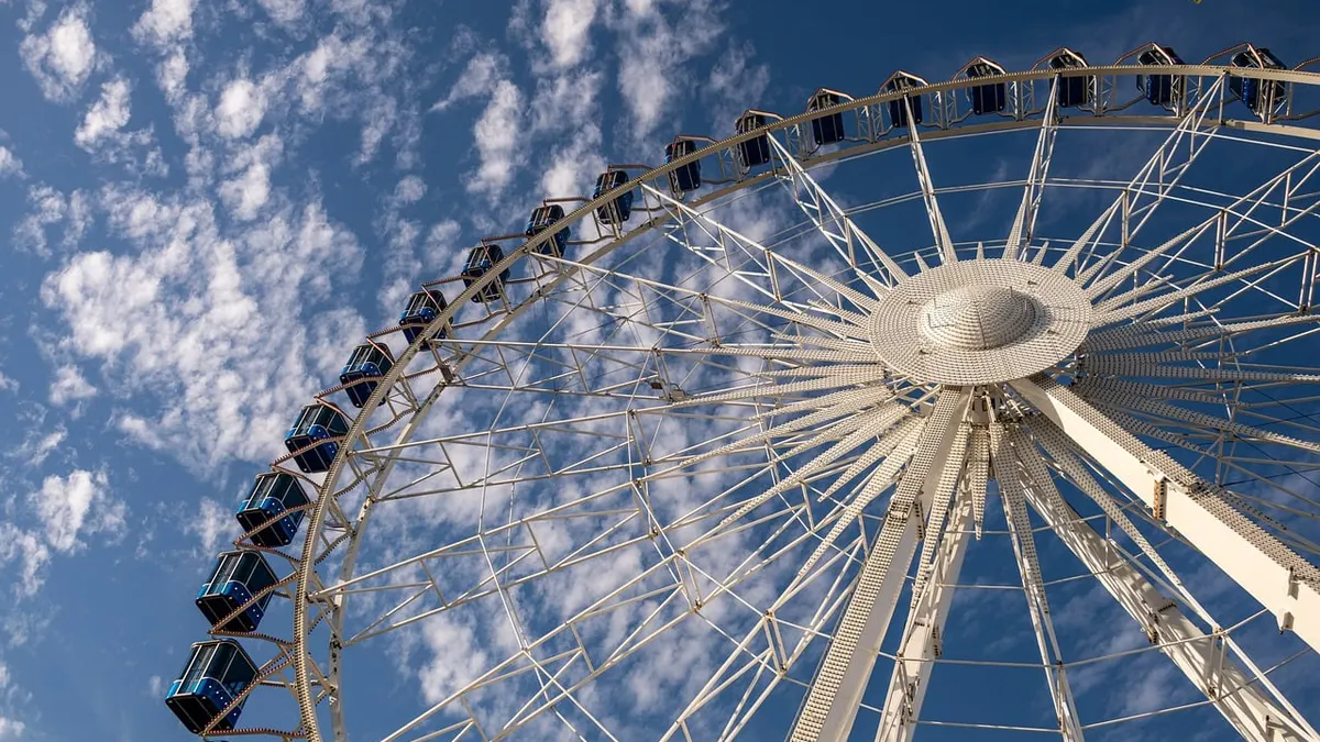 Grande roue, ciel bleu et nuages